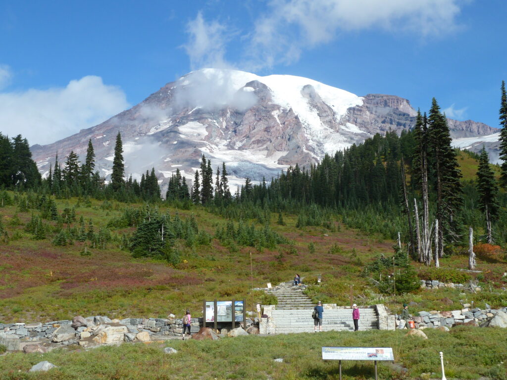 View of Mount Rainier with glaciers visible, and signage in front.